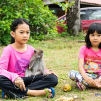 Village girls and infant monkey