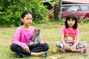 Village girls and infant monkey