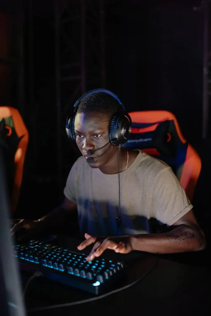 photograph of a man in a gray shirt playing on a computer